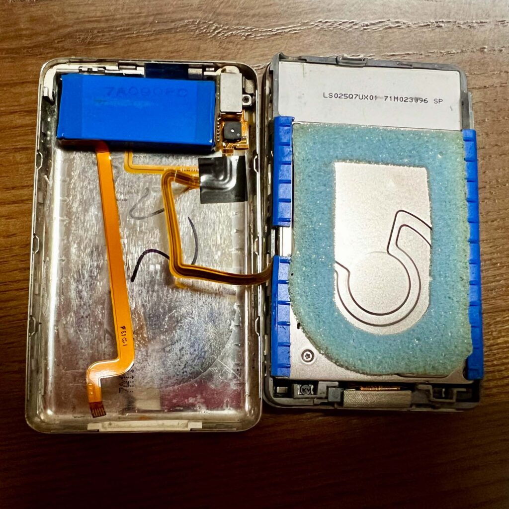 左邊是藍色電池；右邊粉藍色海棉包裹住的就是傳統硬碟。