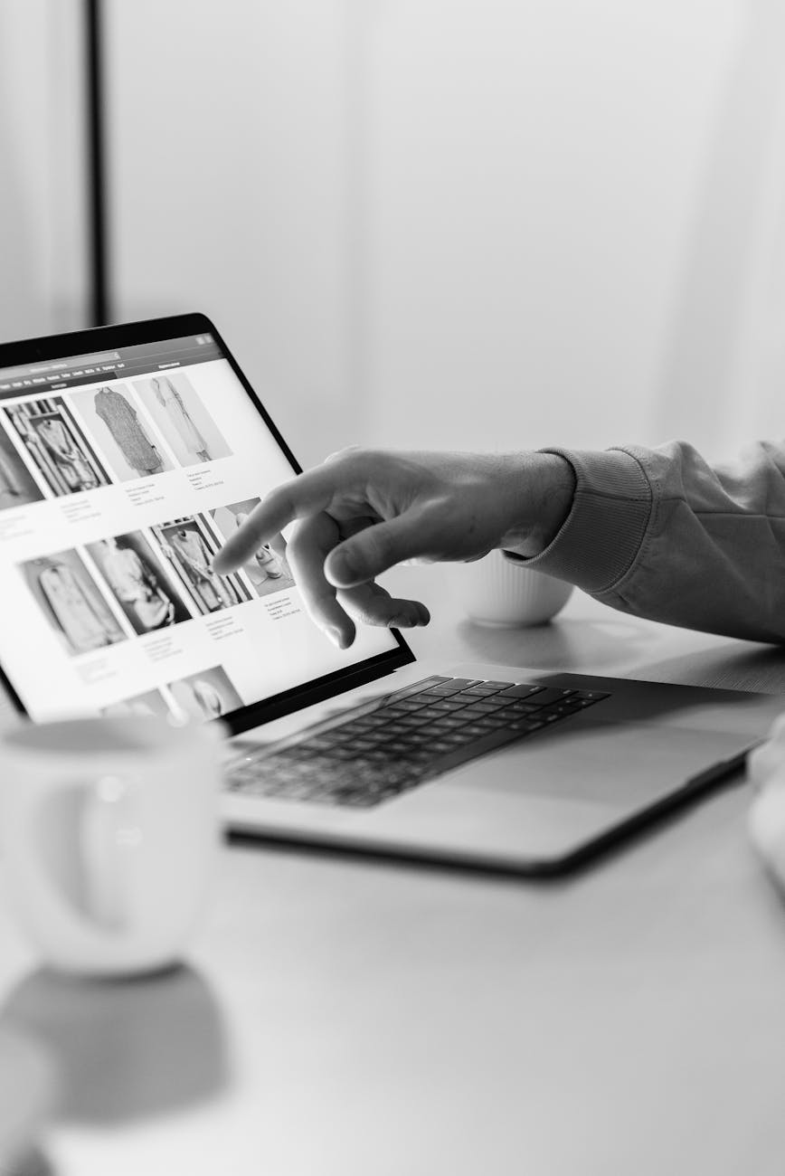 hand pointing on laptop screen with photos